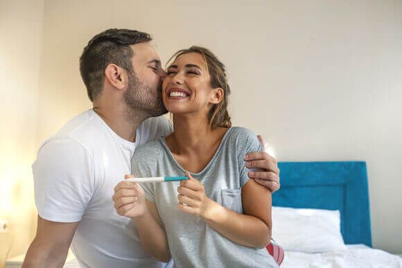 Muškarac ljubi ženu u obraz nakon što su vidjeli test za trudnoću