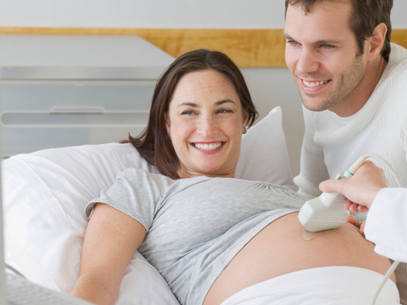 Muž i trudna žena gledaju bebu na ultrazvuku u 29. tjednu trudnoće