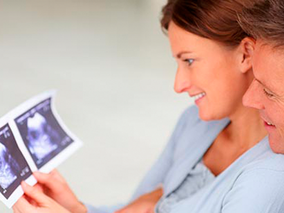 Muškarac i žena zadovoljno gledaju sliku ultrazvuka