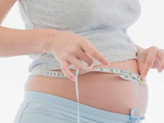 Žena mjeri veličinu trbuha u trudnoći