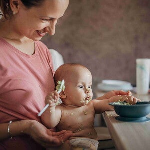 beba odbija hranu tokom obroka dok majka pokušava da je nahrani za stolom