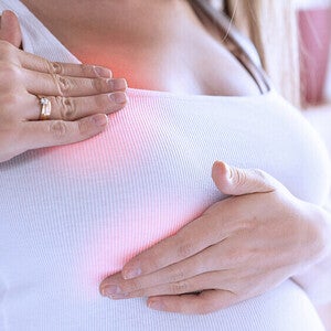 Photo of woman pressing her breast; red area indicates pain