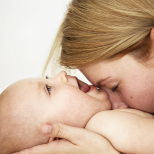 Majka daje poljubac bebi za vrijeme masaže bebe
