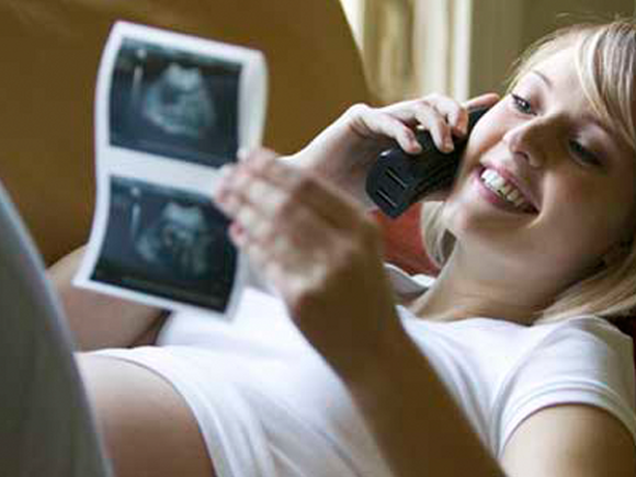 Trudnica se smije i gleda sliku s ultrazvuka