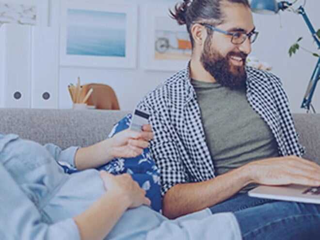 Roditelji sede kod kuće i zajedno planiraju porodični budžet za bebu, razgovarajući o troškovima i finansijama u opuštenom okruženju.