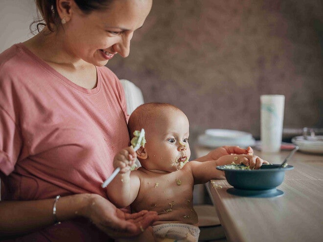 beba odbija hranu tokom obroka dok majka pokušava da je nahrani za stolom