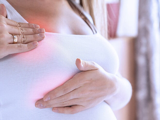 Photo of woman pressing her breast; red area indicates pain