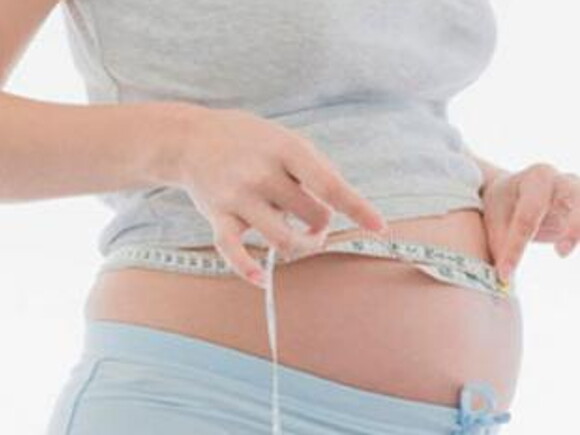 Žena mjeri svoj trudnički trbuh