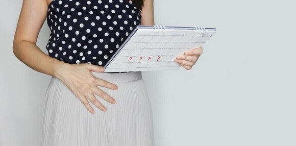 Fotografija trudnice koja drži kalendar na stomaku